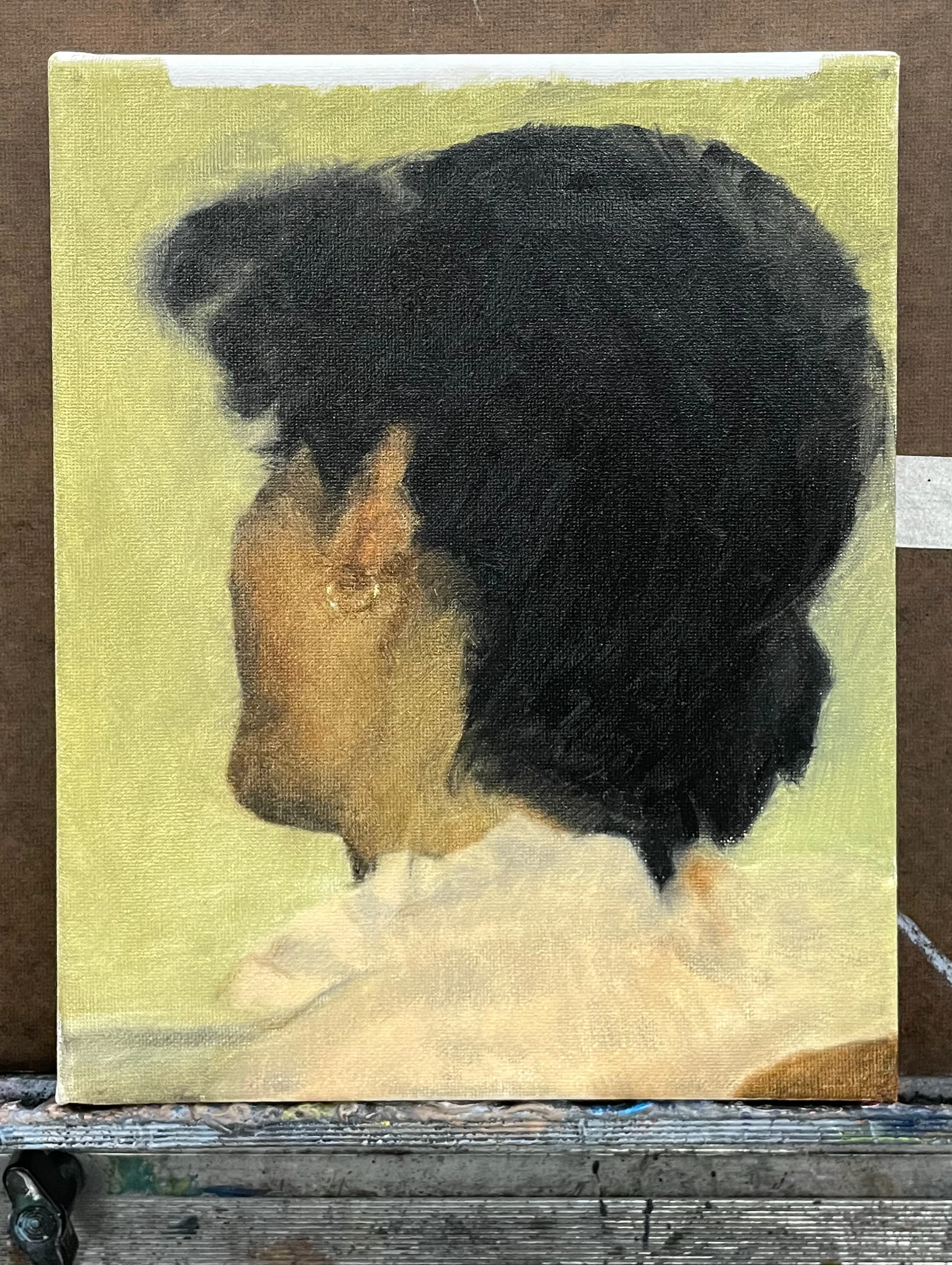 oil painting on stretched canvas of a woman's head over her left shoulder — showing deep black hair, a pale pink collared blouse, and the glint of a golden earring against her jawbone